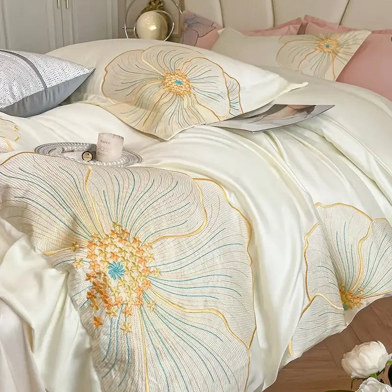 Cream-colored satin bedding set with intricate gold, peach, and teal floral embroidery in embroidered egyptian cotton