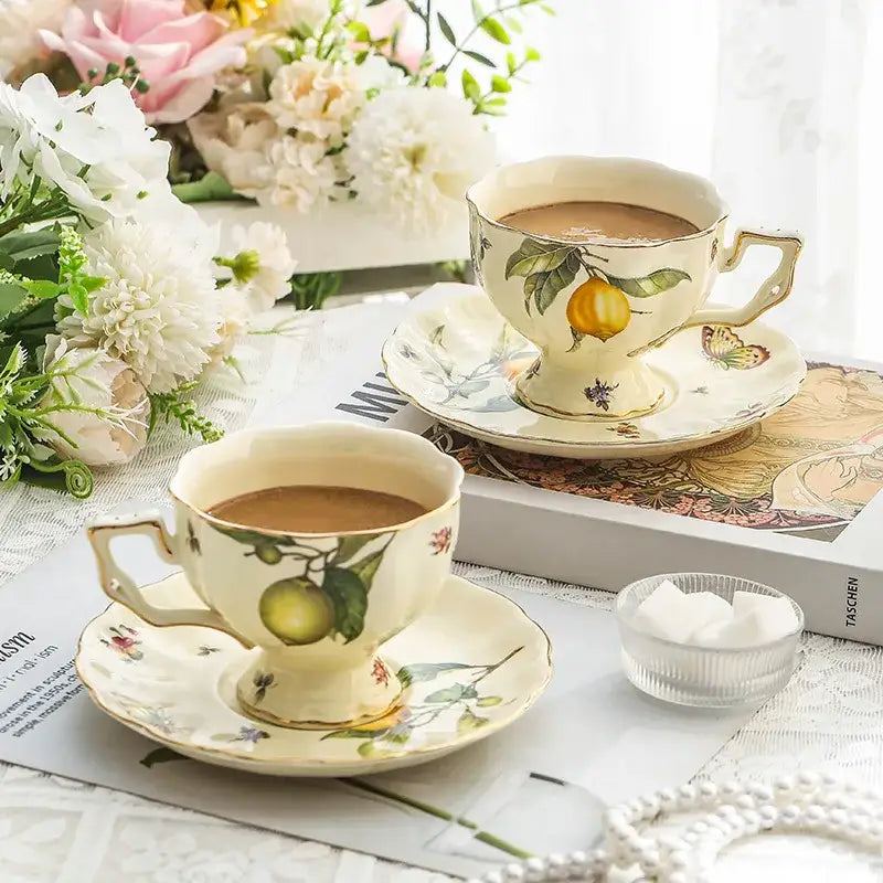 Cream-colored porcelain tea cup with hand-painted lemon motifs and gold trim from floral lemon porcelain tea set