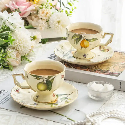 Cream-colored porcelain tea cup with hand-painted lemon motifs and gold trim from floral lemon porcelain tea set