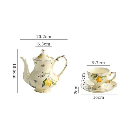 Cream-colored porcelain tea set with delicate yellow lemon and butterfly motifs gold trimmed for dining room use
