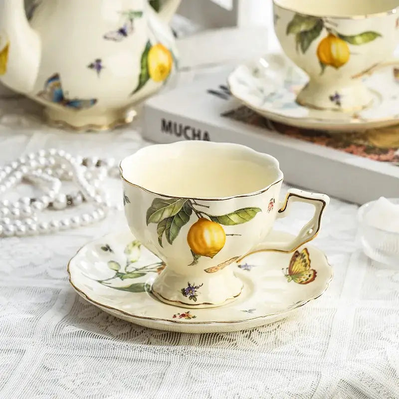 Cream-colored porcelain tea set with hand-painted lemon branches green leaves and butterflies gold trimmed for dining room