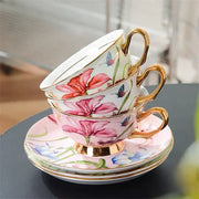 Stacked porcelain lily flower tea set with gold rims, pink floral patterns, and blue butterfly accents for dining room use