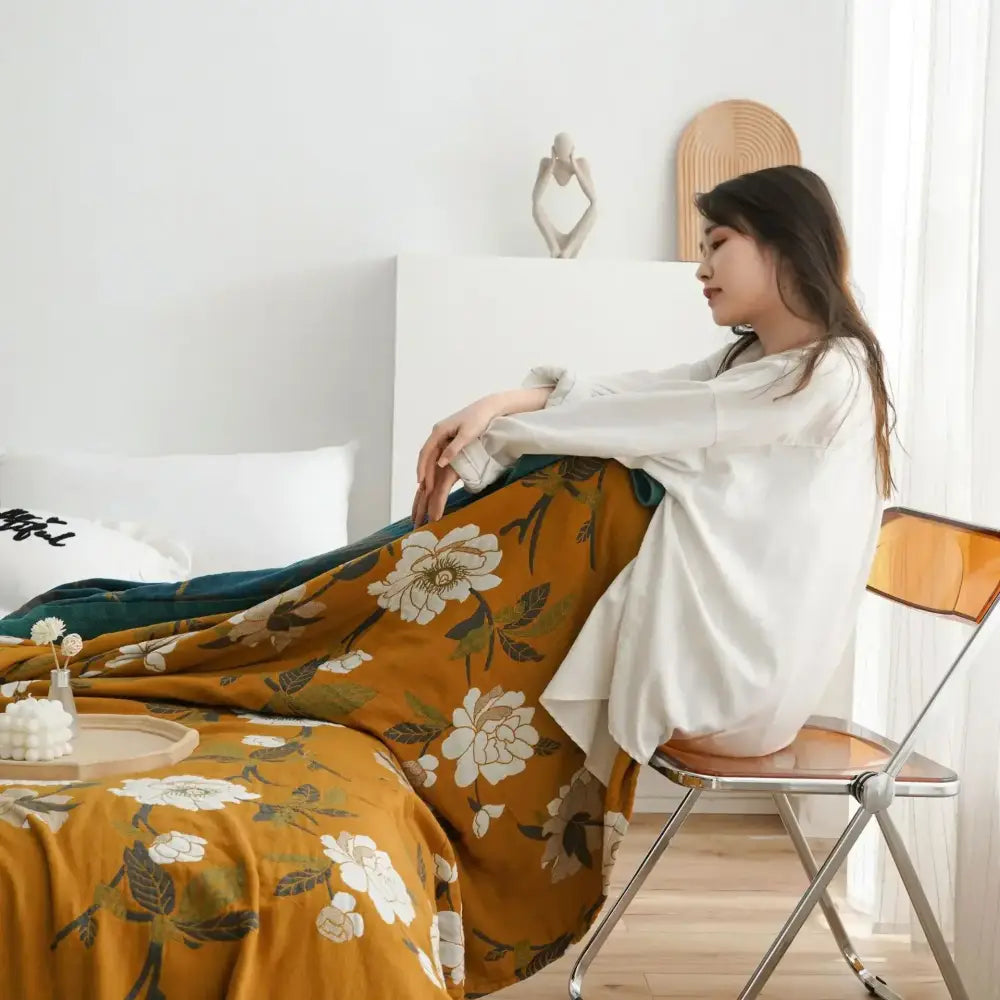 Warm mustard cotton throw blanket with delicate white floral pattern draped elegantly for bedroom decorbites cotton throw
