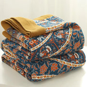 Stacked quilted pants in navy blue with vibrant orange white floral patterns and mustard yellow cuff for decorbites cotton picnic blanket bedspread