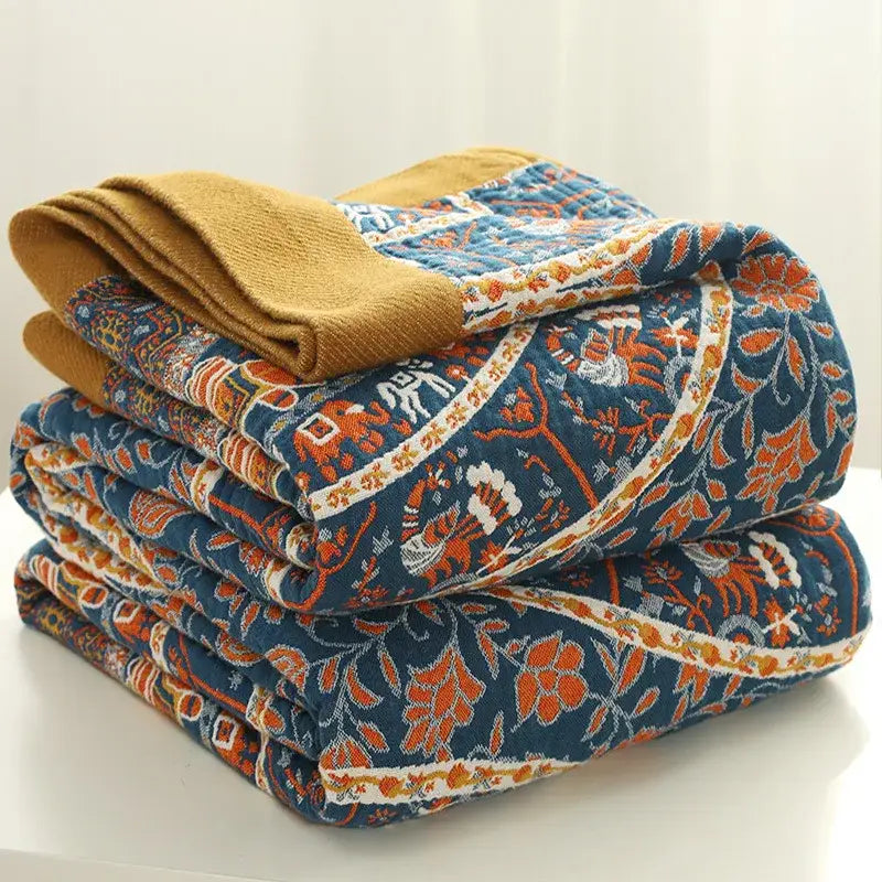 Stacked quilted pants in navy blue with vibrant orange white floral patterns and mustard yellow cuff for decorbites cotton picnic blanket bedspread