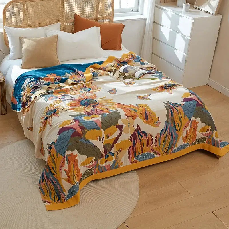 A vibrant floral orange and blue cotton summer throw blanket with bold sunflowers on cream decorbites cotton summer decor