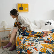 A vibrant floral orange and blue cotton summer throw blanket with bold patterns on a white base for bedroom decorbites cotton summer