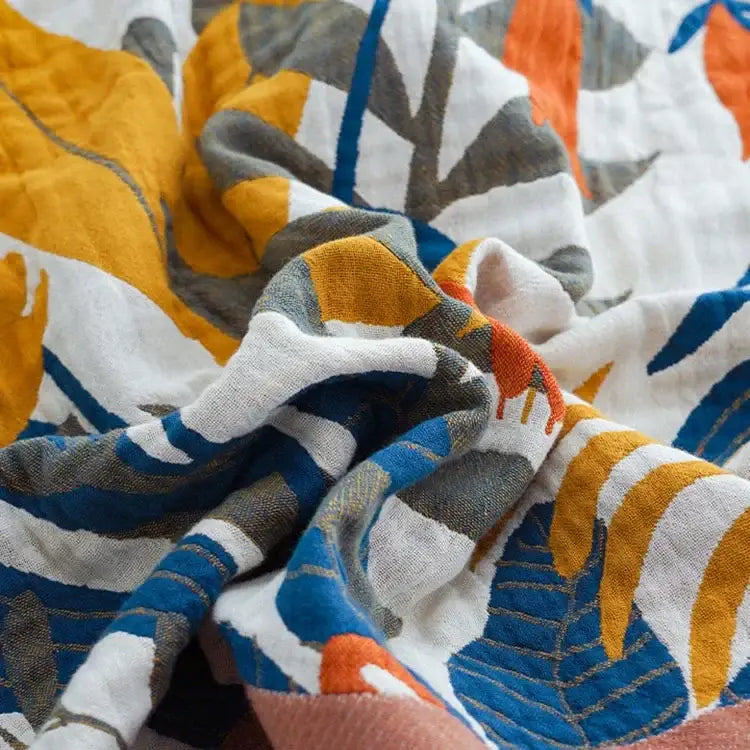 Floral orange and blue cotton summer throw blanket with vibrant tropical leaf pattern in bold yellow blue gray hues decorbites cotton summer