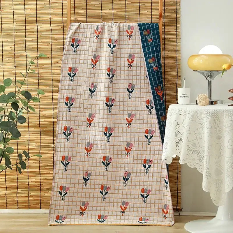 A soft cream-colored quilted cotton gauze adult bath towel with pink and orange tulip floral pattern for bedroom decorbites decor