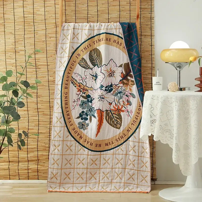 A cream quilted cotton gauze adult bath towel with floral motifs and embroidered decorbites cotton gauze border decor