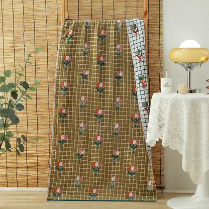 A cozy cotton gauze adult bath towel featuring floral and bunny motifs in soft blues, oranges, creams, and greens decorbites cotton gauze