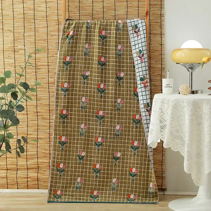 A cozy cotton gauze adult bath towel featuring floral and bunny motifs in soft blues, oranges, creams, and greens decorbites cotton gauze