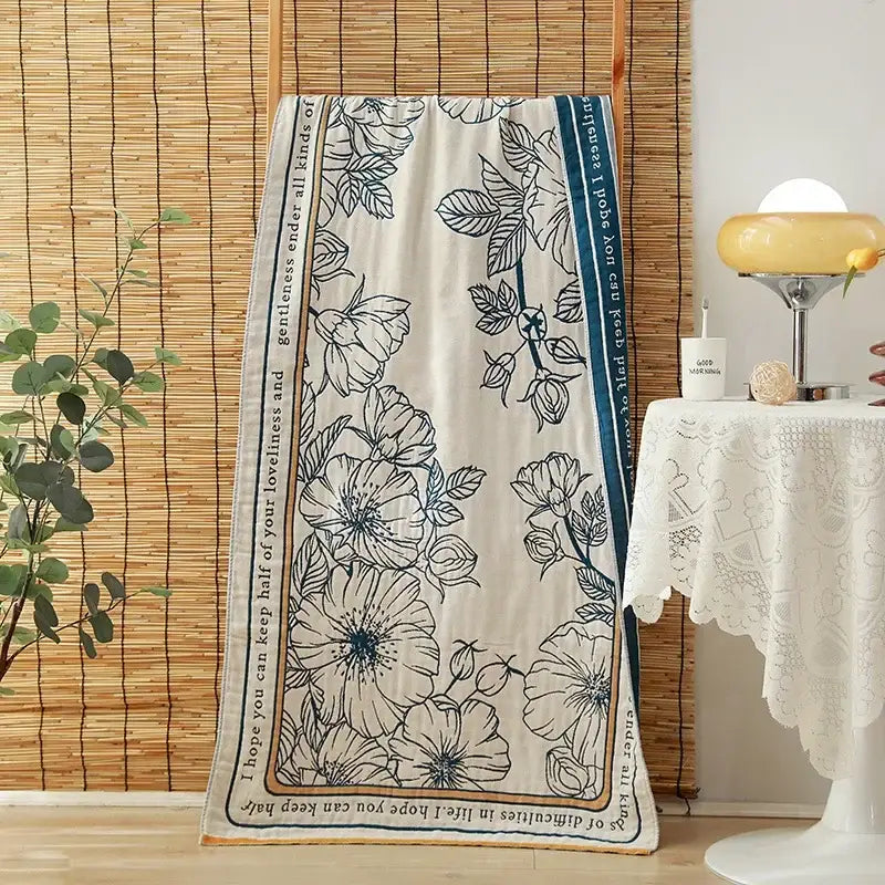 A cream-colored cotton gauze adult scarf with black floral botanical illustrations and inspirational text for decorbites bath towels decor