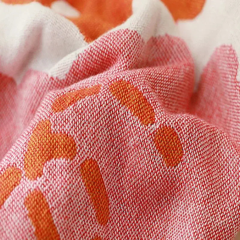 A soft pink and orange patterned cotton gauze adult bath towel with textured weave for decorbites bedroom decor