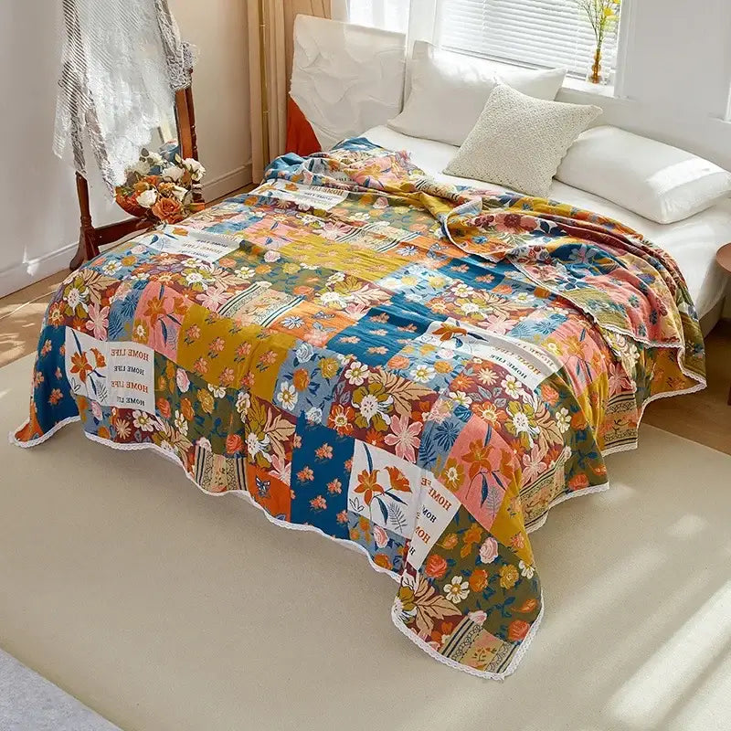 A vibrant floral patchwork breathable cotton gauze sofa cover in warm tones with a scalloped white edge for living room decor