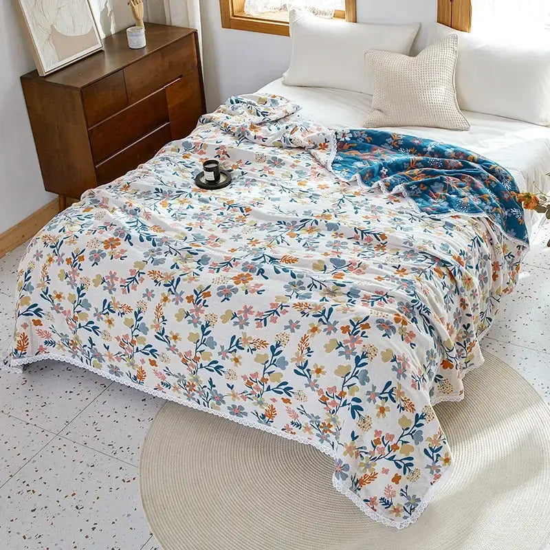 A soft white floral sofa cover with delicate pastel blossoms edged with lace made of decorbites breathable cotton gauze