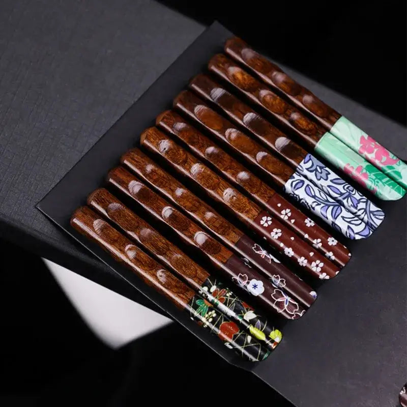 Set of ten handcrafted bamboo wood chopsticks with polished brown bodies and floral patterned ends for dining experience