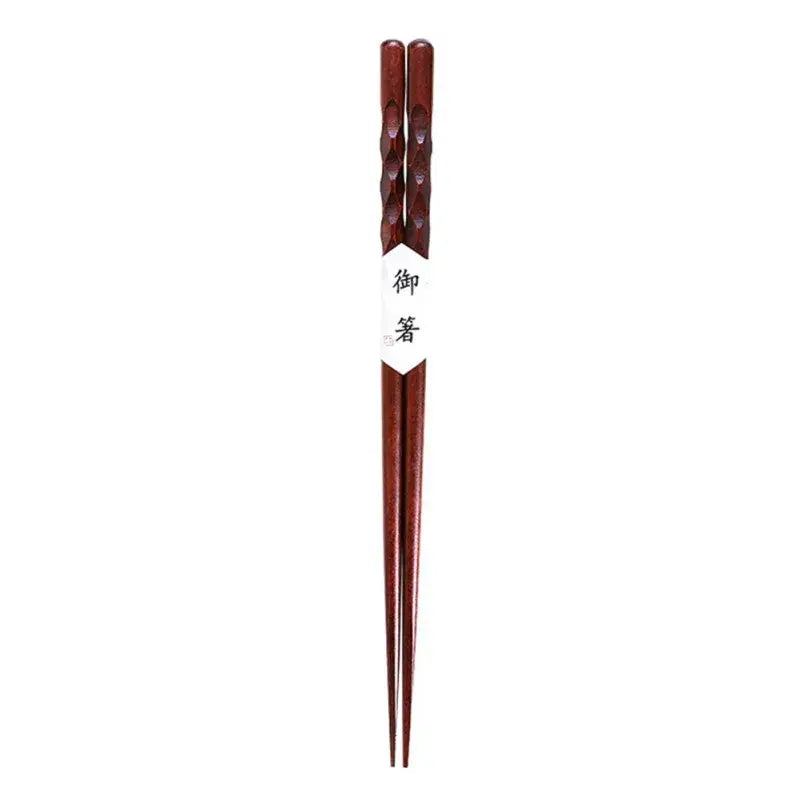 Dark brown bamboo wood chopsticks with twisted handles and a white paper band featuring japanese characters
