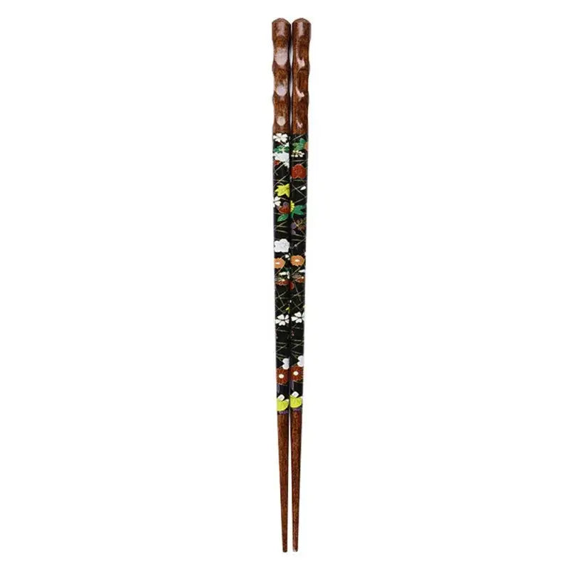 A pair of dark brown bamboo wood chopsticks with black lacquer and intricate floral patterns in a dining gift box