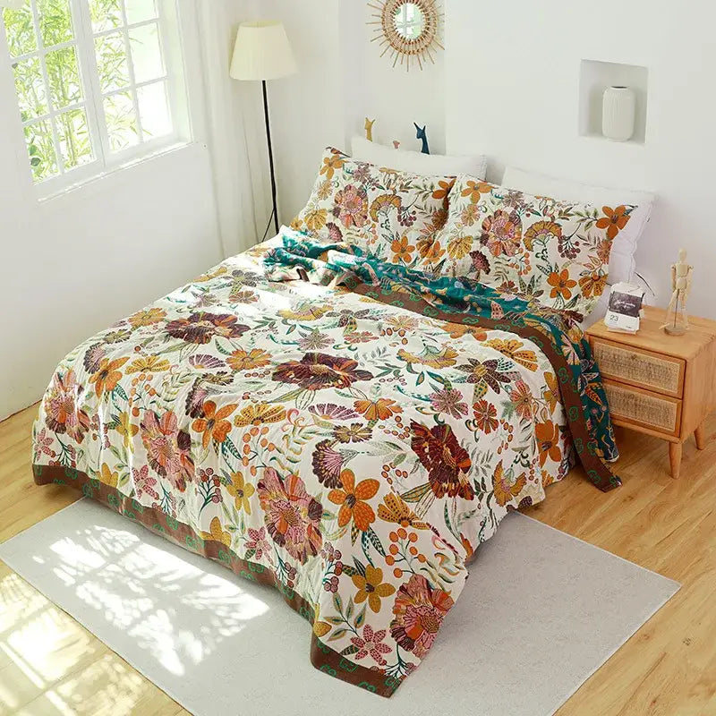 A cozy decorbites cotton gauze towel blanket with vibrant autumnal floral pattern in orange rust and teal