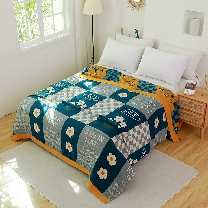 Cozy teal and yellow patchwork towel blanket with white daisy prints and fall in love text in decorbites cotton gauze