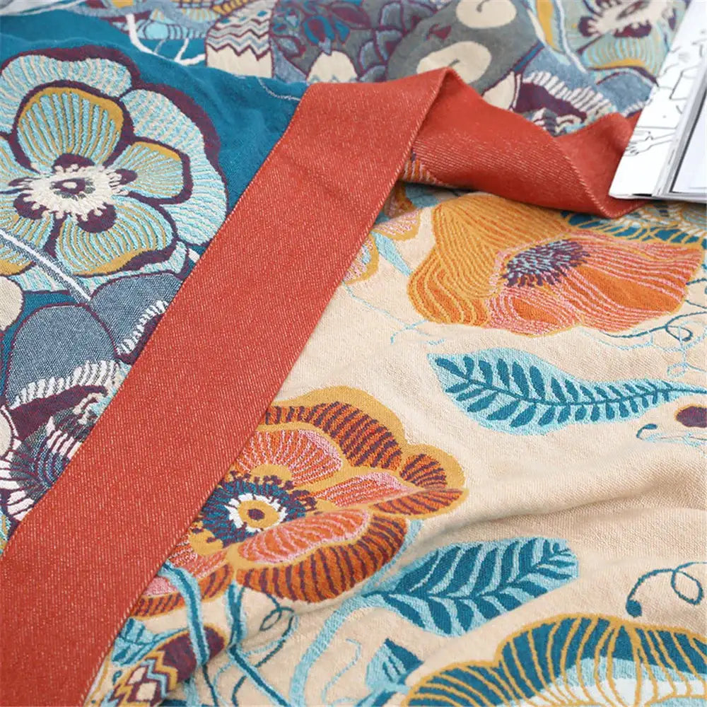 Vibrant embroidered floral decorbites cotton gauze towel blanket in bold orange and teal on cream background for bedroom decor