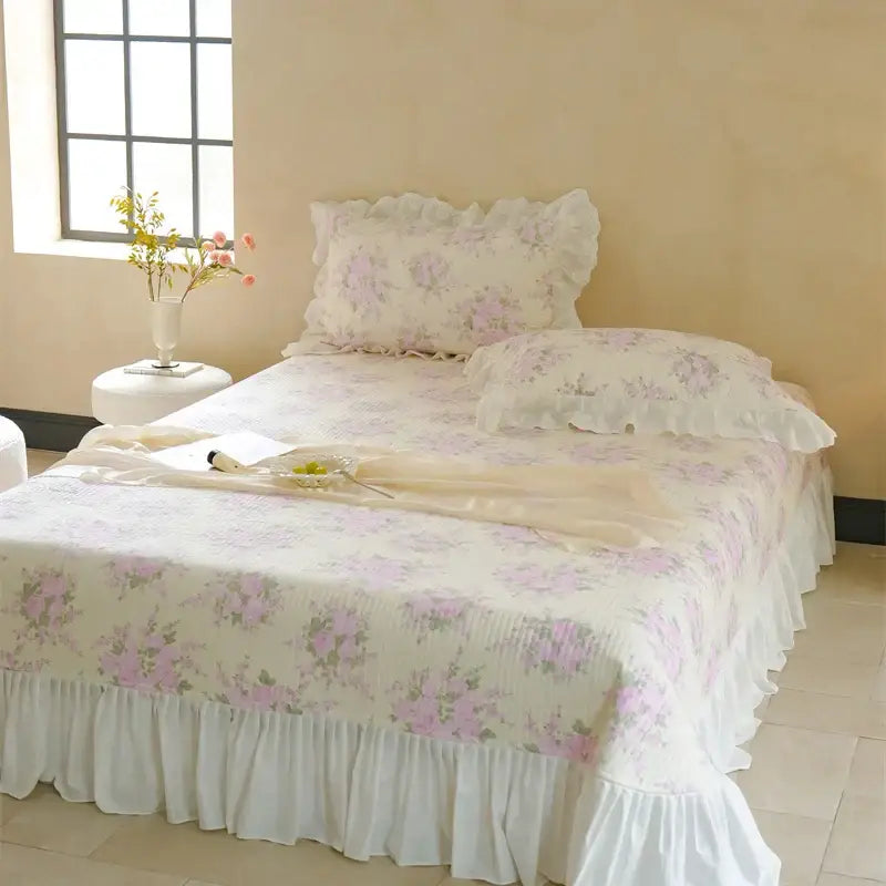 Delicate white and pink quilted bedspread set with soft lavender floral patterns and ruffled edges for bedroom decor