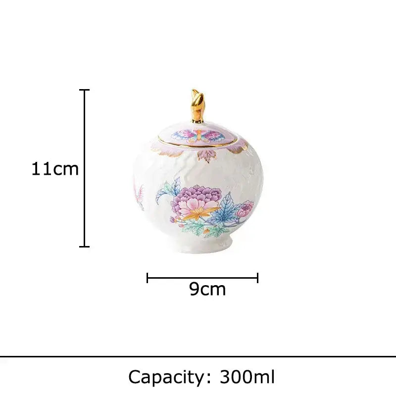 Delicate white porcelain sugar bowl with hand-painted floral patterns and gold bird lid in floral pink purple coffee mug set