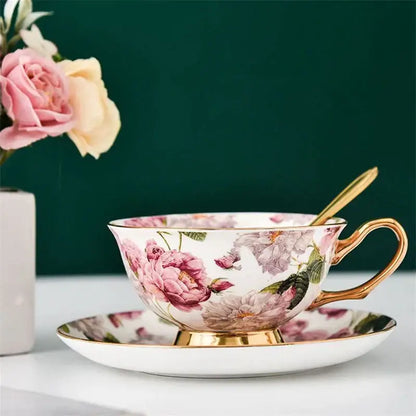 Elegant floral pink and purple porcelain tea cup set with gold-trimmed rim and handle on matching saucer