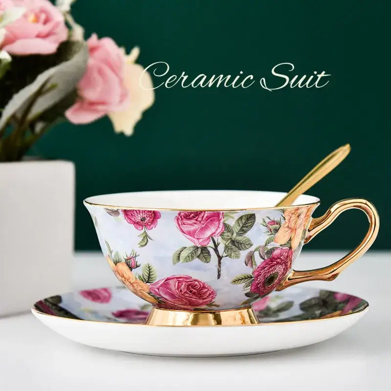 Delicate floral pink and purple porcelain tea cup set with gold trim featuring vibrant roses and green leaves