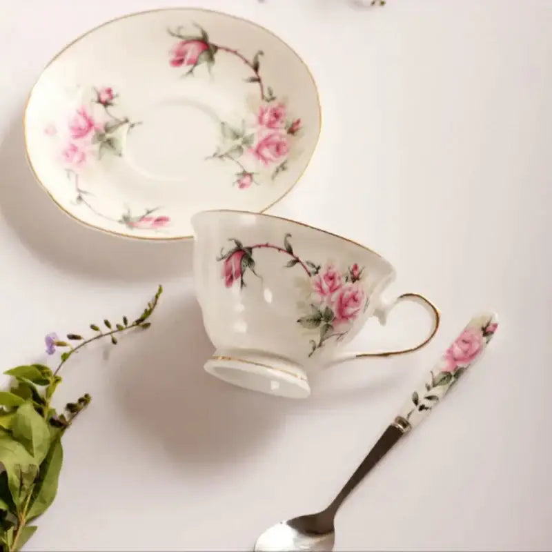 Delicate white porcelain tea cup set with hand-painted pink roses and green vines for dining room coffeeware