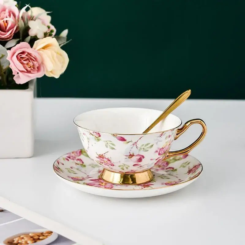 Delicate white porcelain tea cup set with pink floral pattern and gold-trimmed edges for dining room use