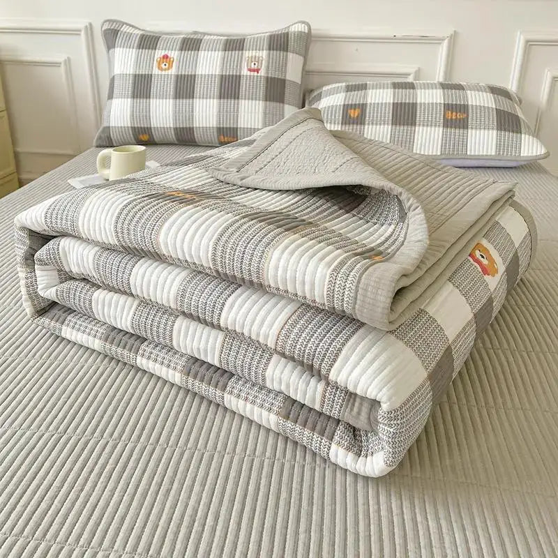 Gray and white checkered quilt with embroidered bear faces folded on bed complements floral pink and white cartoon small bed sheets decorbites cartoon small fresh bedroom quilt