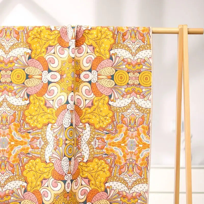 A vibrant floral pink and yellow cotton gauze bath towel with intricate patterns ideal for bathroom decorbites cotton gauze decor