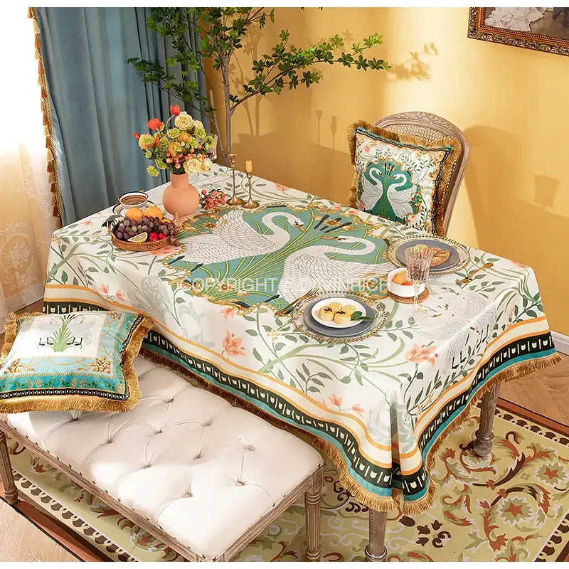 Elegant white floral print velvet tablecloth with green and teal swan motifs and gold-trimmed tassel edges for dining decor