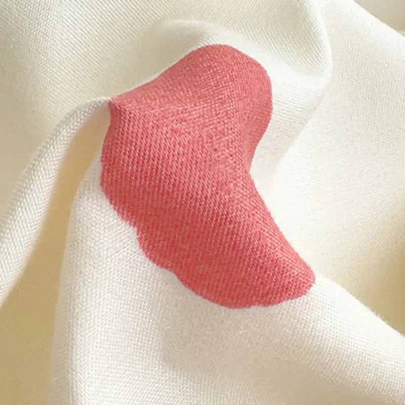 A soft coral-pink knitted fabric patch with scalloped edge on cream textile in floral puppy cotton printed bedding set decorbites cotton printed