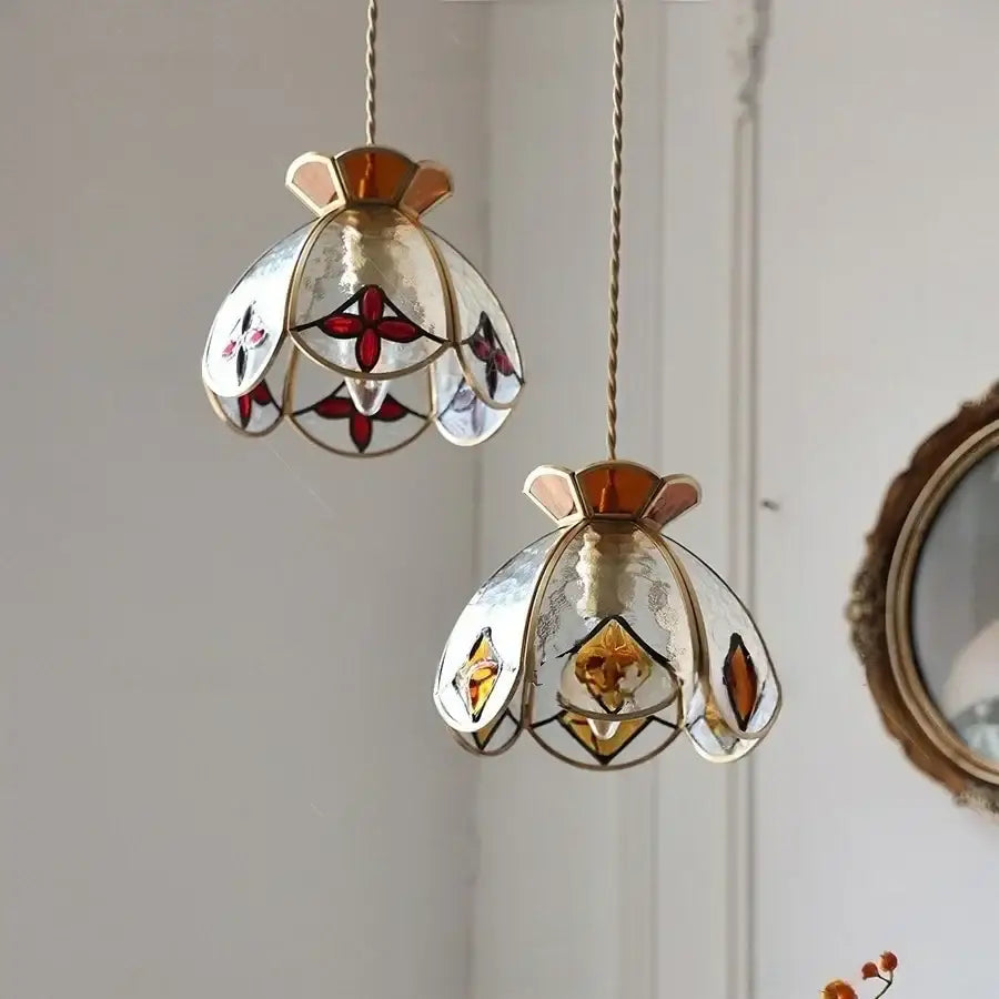 Two handcrafted floral red and amber glass pendant lamps with amber-toned metal frames by decorbites crown diamond