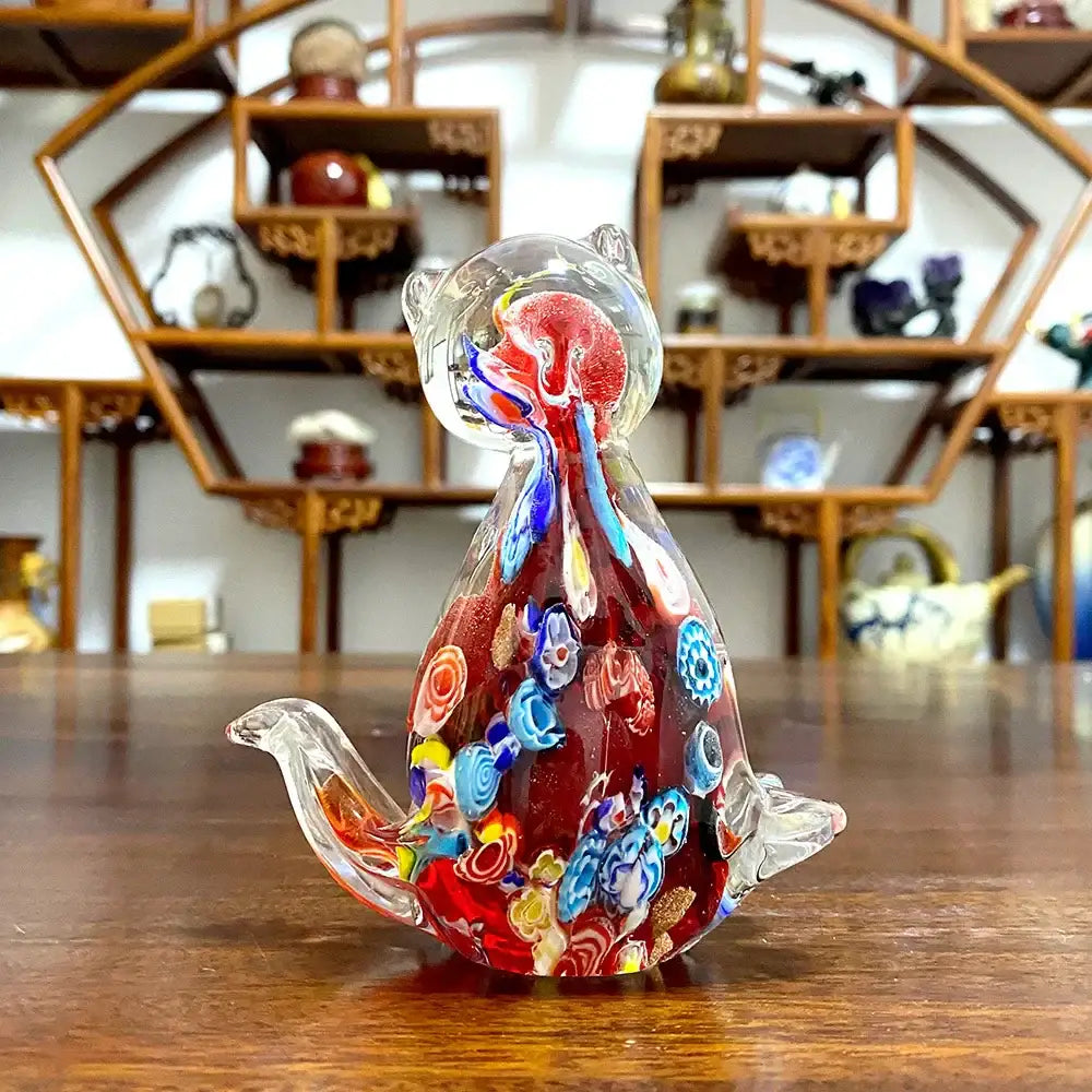 A vibrant red cute cat glass figurine with intricate blue yellow and white floral patterns for living room decor