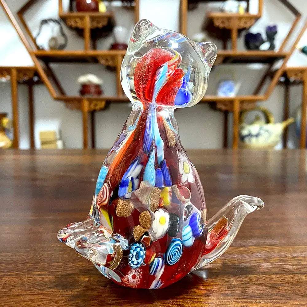 A vibrant translucent glass cat figurine with red blue and gold floral patterns for cute cat glass decor