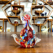 A vibrant red cute cat glass figurine with intricate blue yellow and white floral patterns for living room decor