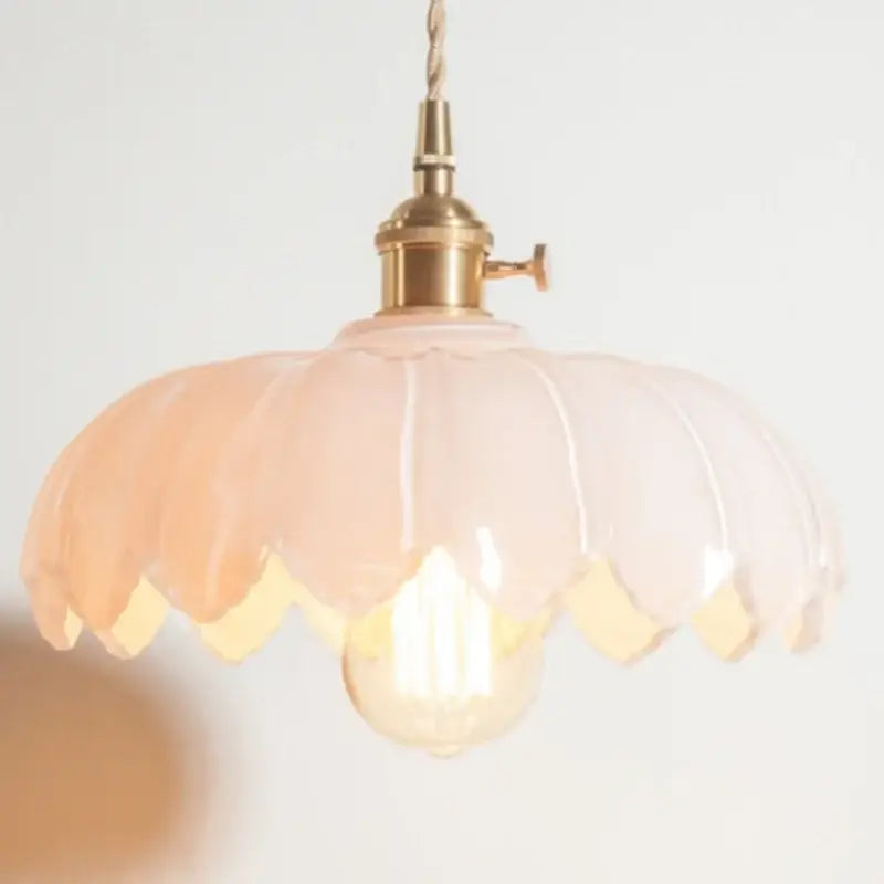 Peach-colored glass pendant lamp with brass decorbites brass glass fixture and twisted cord for bedroom lighting