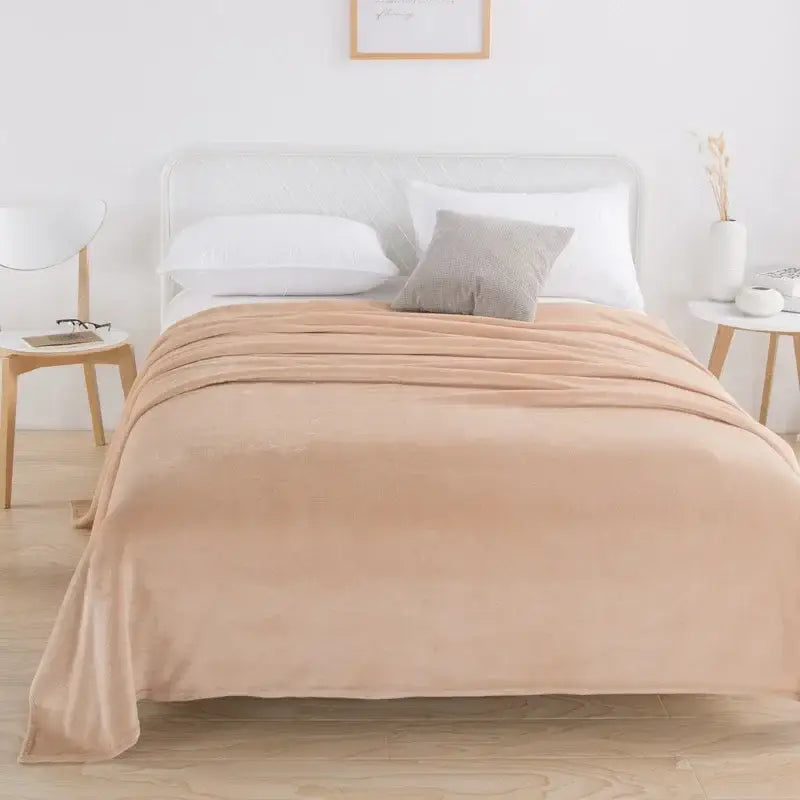 Beige plush throw blanket draped over bed featuring soft coral fleece flannel flower fabric for bedroom decorbites decor
