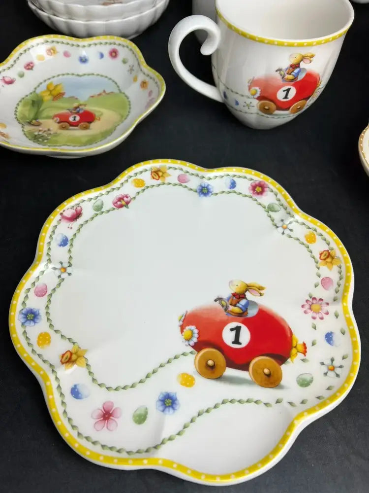 White porcelain tulip dinnerware set plate with scalloped edge featuring a bunny race car and floral pattern border