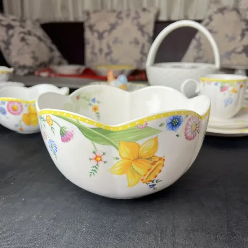 A white porcelain bowl with scalloped rim and colorful floral patterns from the floral scalloped white tulip dinnerware set