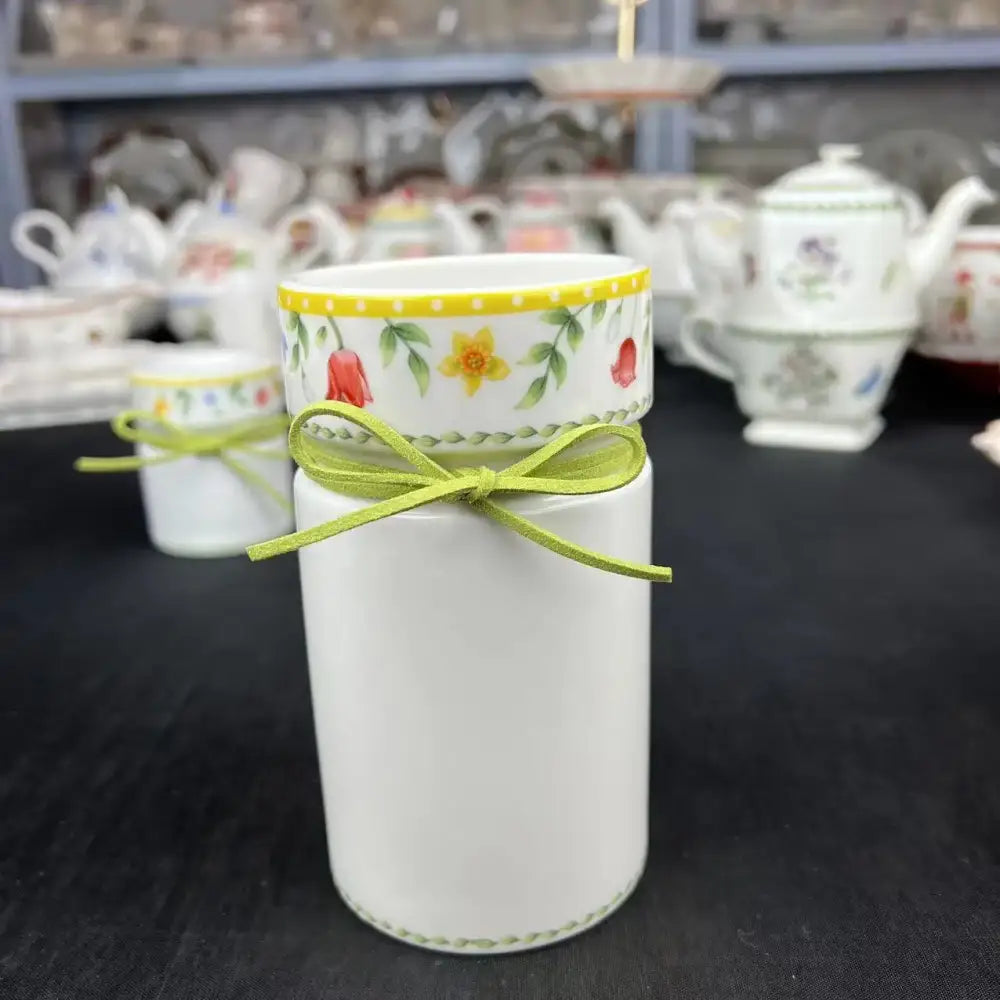 White ceramic toothbrush holder with floral band and lime ribbon complements easter tulip dinnerware set