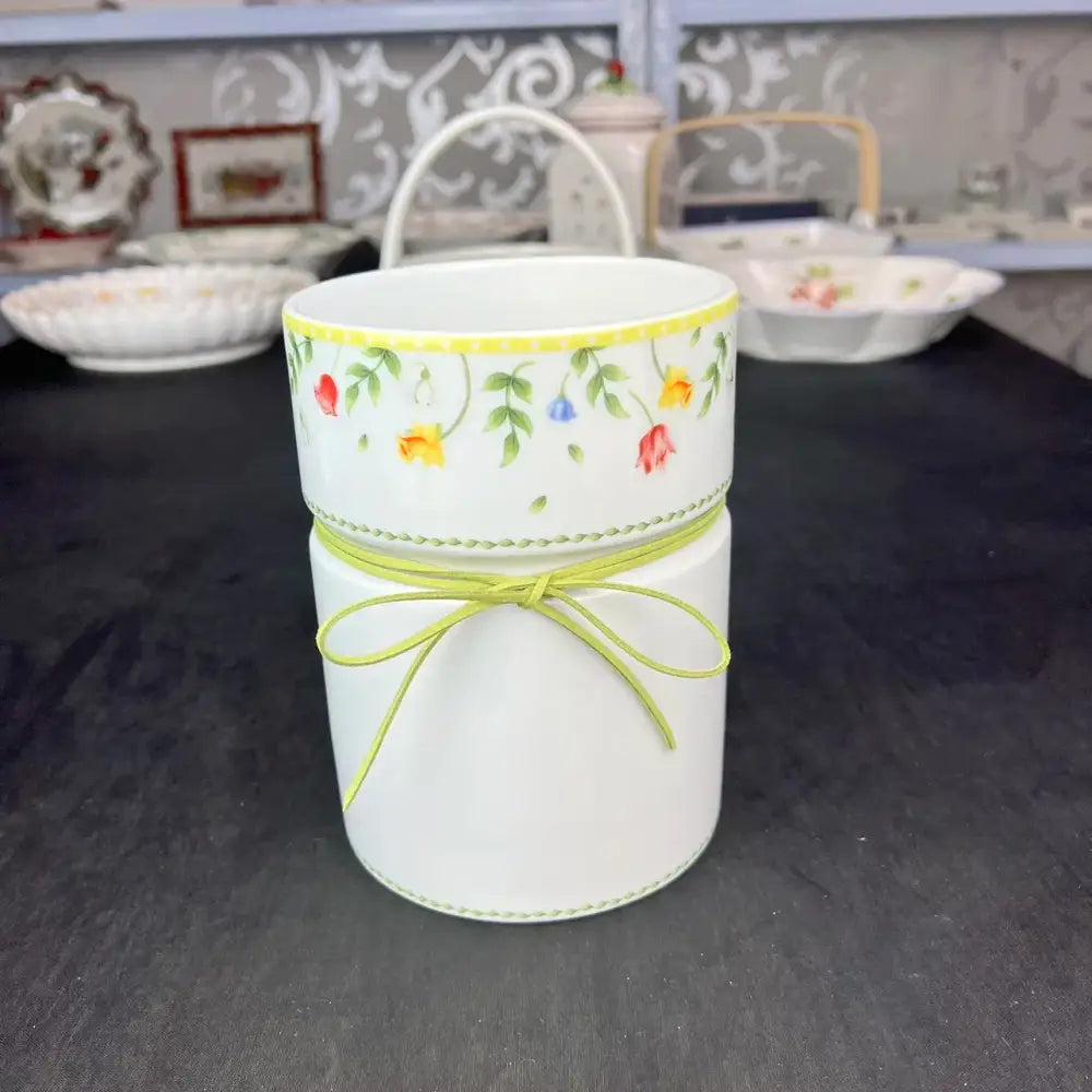 White ceramic toothbrush holder with floral pattern and green ribbon bow from easter tulip dinnerware set
