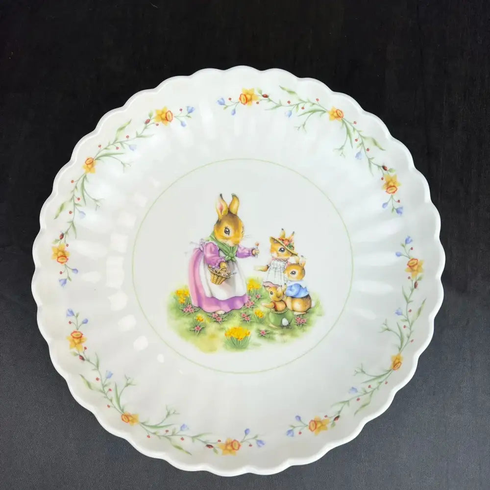 A delicate white porcelain tulip dinnerware set bowl featuring beatrix potter peter rabbit family with floral scalloped edges