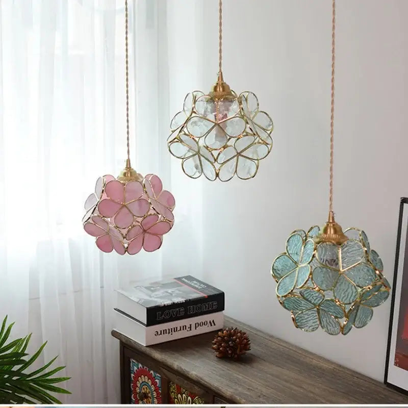 Three floral stained glass copper led pendant lamps with translucent pink, clear, and teal petals for dining room use