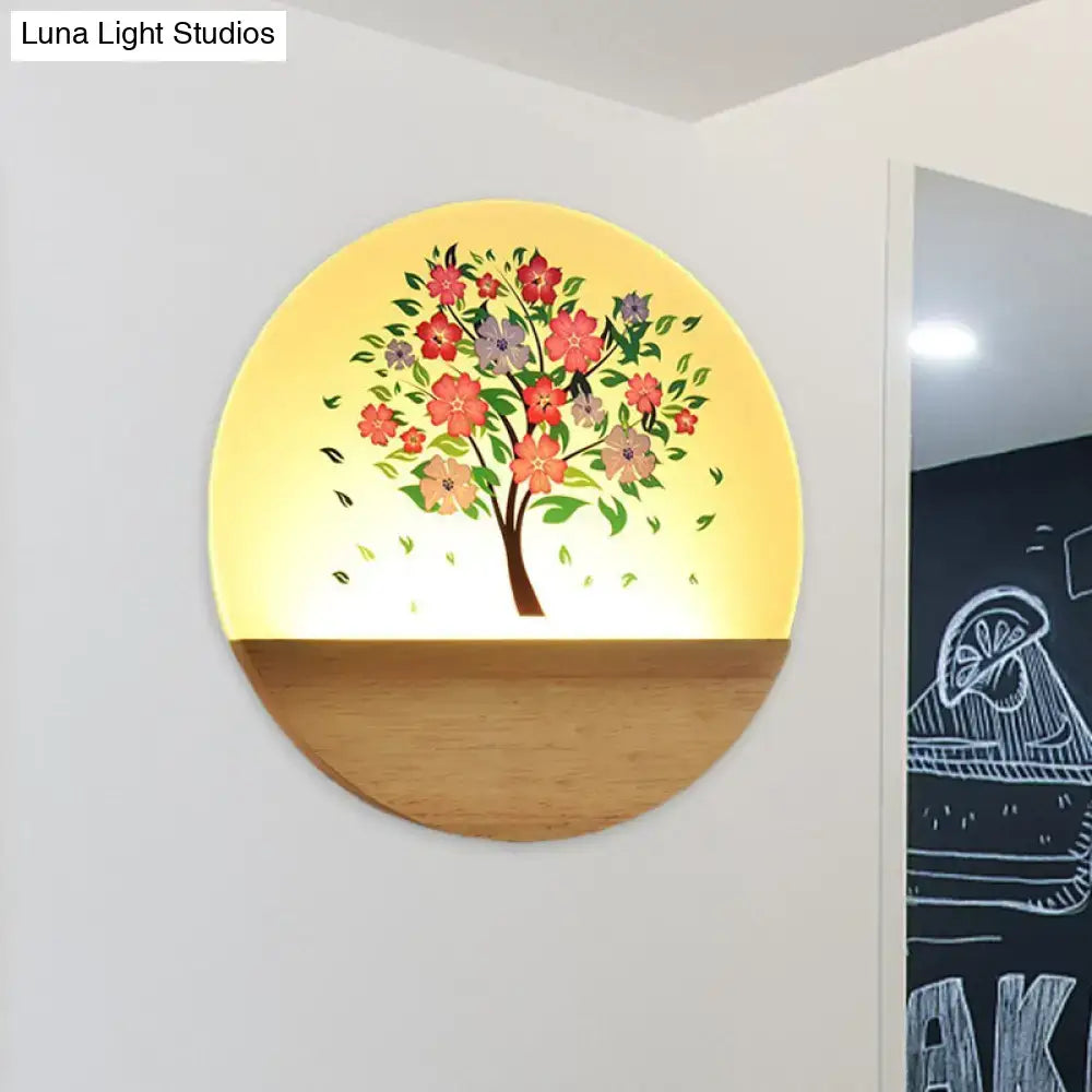 Circular wall light with warm yellow glow featuring an acrylic shade painted with animal flowering tree design on wood base