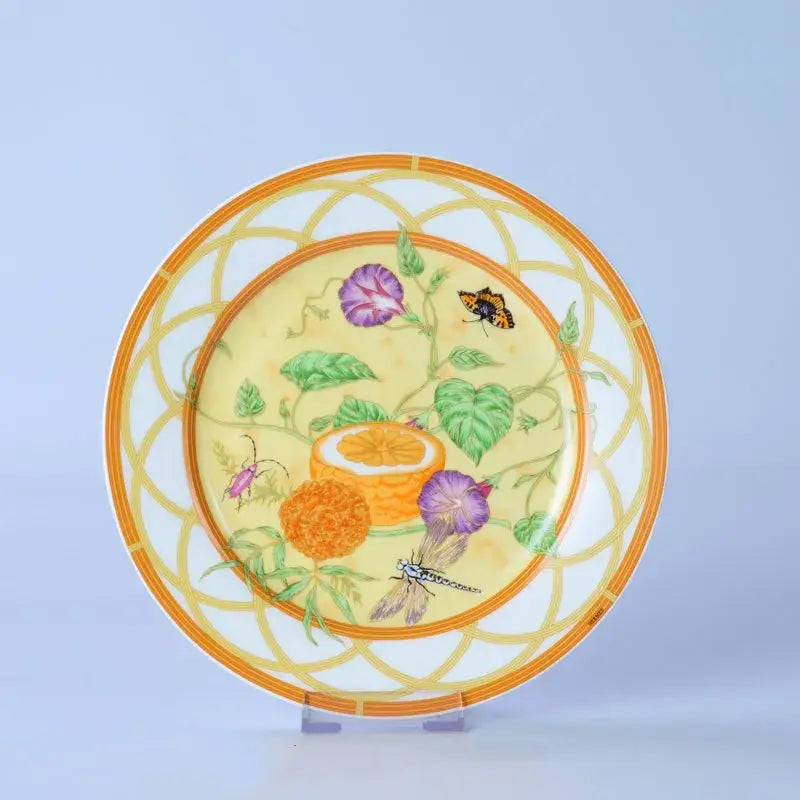 A vibrant yellow and orange decorative ceramic plate from the floral turquoise and gold bone dinnerware set